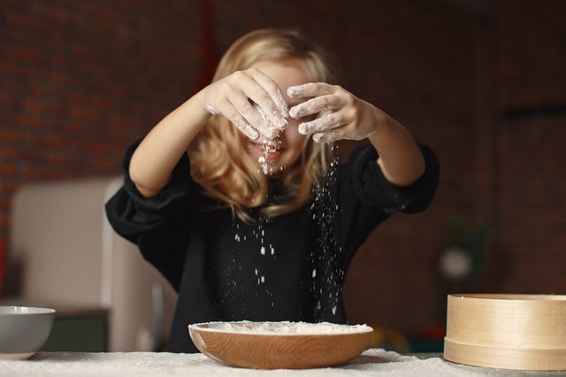 girl-in-black-sweatshirt-sifting-flour-3984744